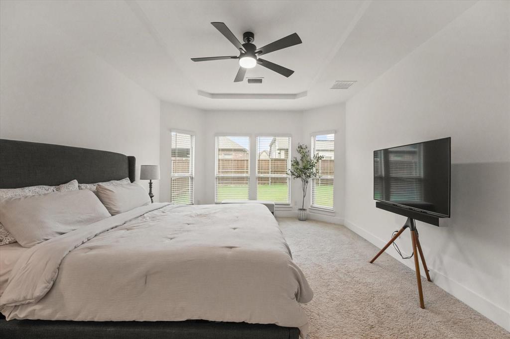 1714 Highwood Road Forney, TX 75126 - Photo 22 of 28 Bedroom with light carpet, a ceiling fan, and a tray ceiling