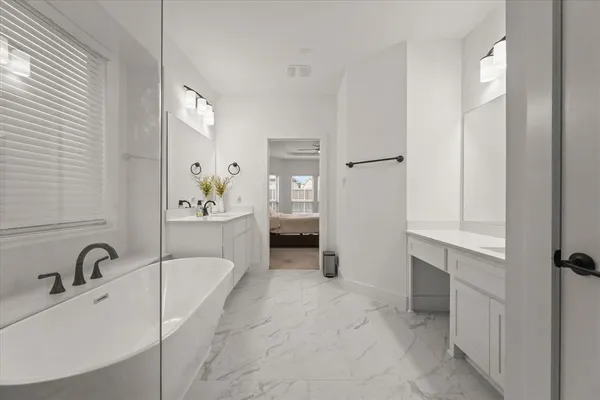 a spacious bathroom with a tub sink and mirror