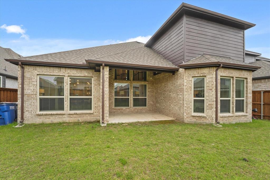 1714 Highwood Road Forney, TX 75126 - Photo 27 of 28 Back of property featuring a shingled roof, brick siding, and a patio area
