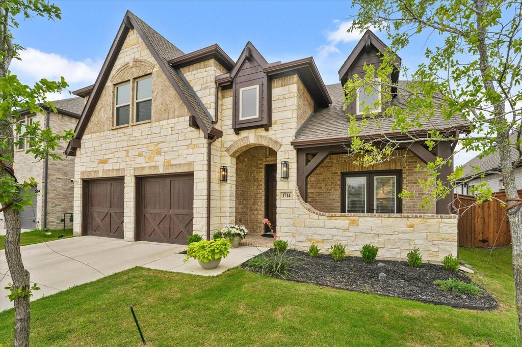 1714 Highwood Road Forney, TX 75126 - Photo 28 of 28 View of front of house featuring stone siding, a shingled roof, a garage, and concrete driveway