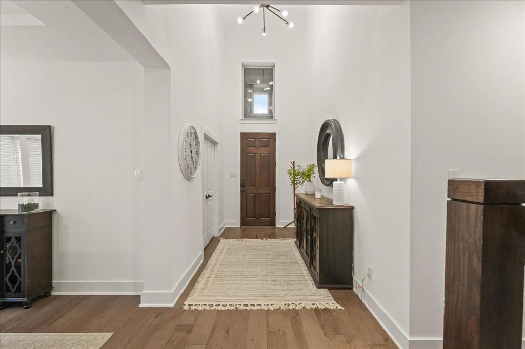1714 Highwood Road Forney, TX 75126 - Photo 4 of 28 Entrance foyer with a high ceiling, dark wood-style floors, and suspended lighting
