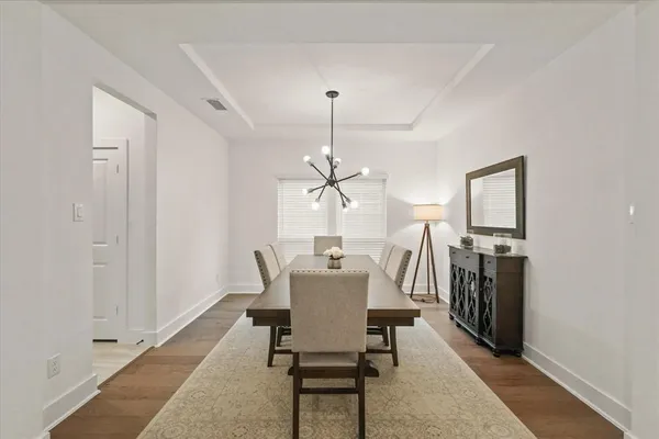 a dining room with furniture window and wooden floor