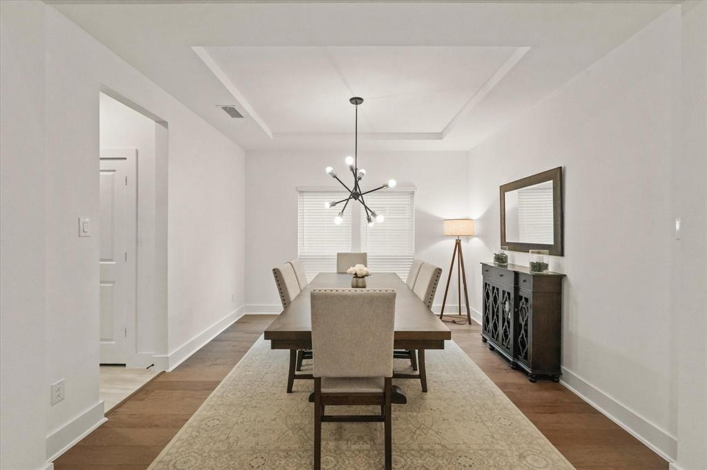 1714 Highwood Road Forney, TX 75126 - Photo 5 of 28 Dining room with hanging lights, wood finished floors, and a raised ceiling
