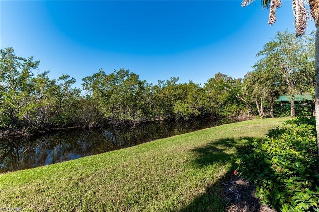 4705 Hawks Nest Way, Unit F101 Naples, FL 34114 - Photo 26 of 41 a view of a lake with a yard