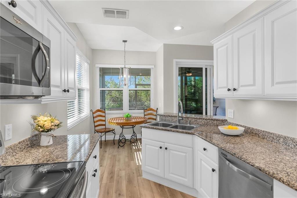 4705 Hawks Nest Way, Unit F101 Naples, FL 34114 - Photo 9 of 41 a kitchen with a sink stove and cabinets