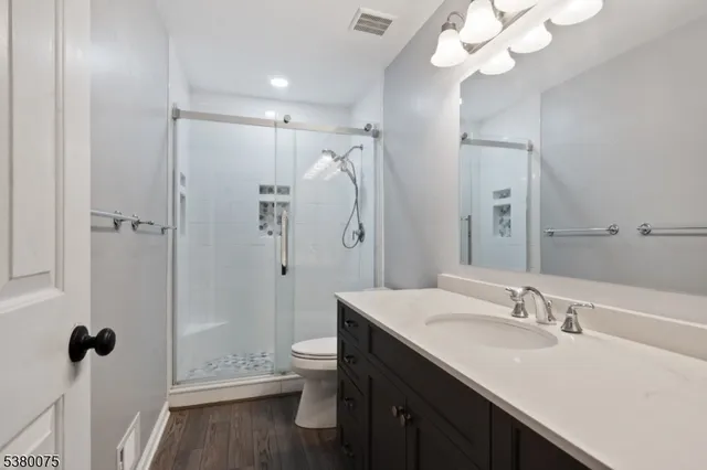 a bathroom with a sink a toilet and shower