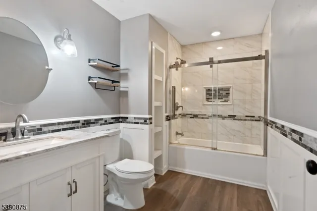 a bathroom with a granite countertop sink toilet and shower