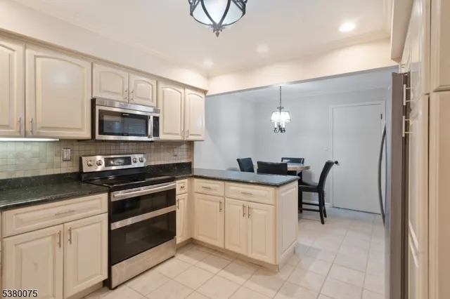 a kitchen with stainless steel appliances a stove a sink cabinets and a refrigerator