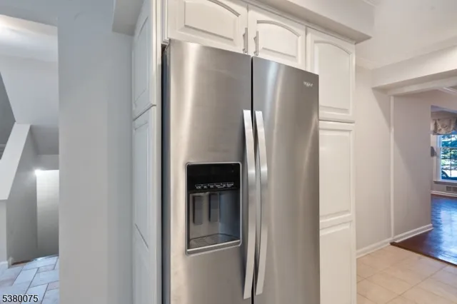 a metallic refrigerator freezer sitting in a kitchen