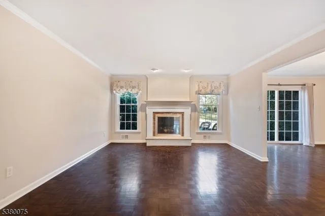 an empty room with wooden floor and a fireplace