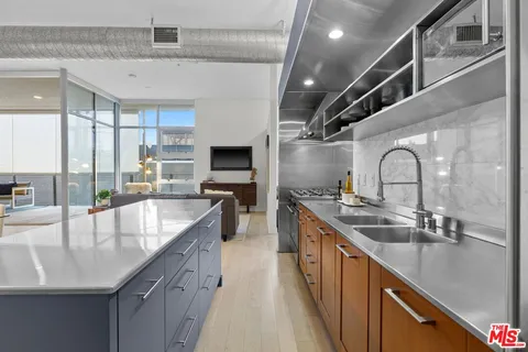 a large kitchen with stainless steel appliances granite countertop a sink window and cabinets