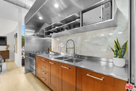 a kitchen with stainless steel appliances granite countertop a sink a stove and cabinets