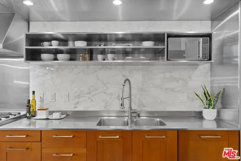 a kitchen with granite countertop a sink a stove and cabinets