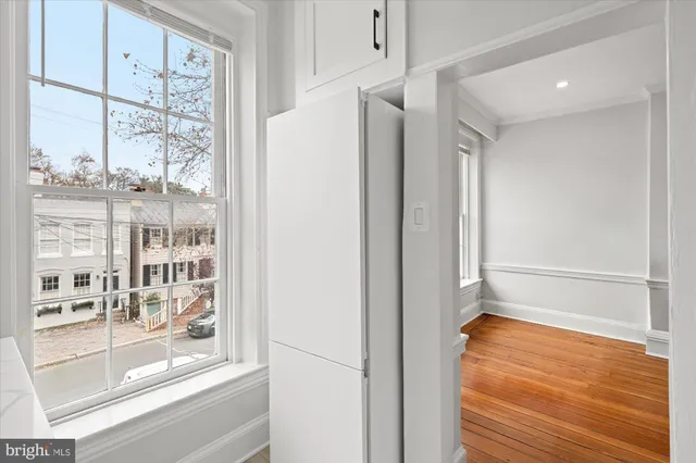 an empty room with wooden floor and windows