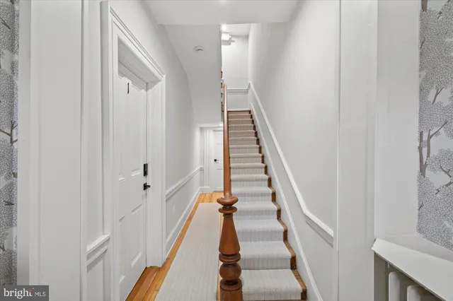 a view of entryway and hall with wooden floor