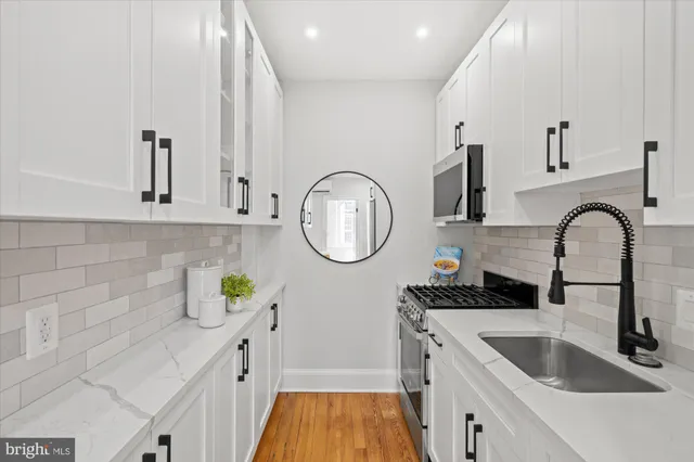 a kitchen with stainless steel appliances a white cabinet and a granite top