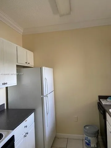 a kitchen with a refrigerator and cabinets