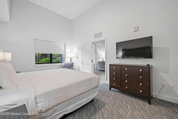 a bedroom with a bed and a flat screen tv