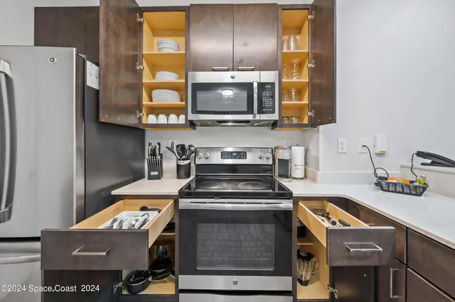a large white kitchen with a sink and dishwasher a stove with wooden floor