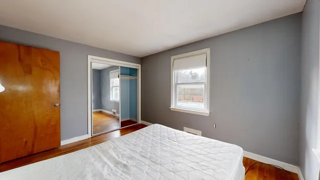 a bedroom with a bed and wooden floor