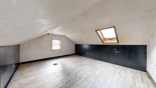 a view of a big room with wooden floor and windows