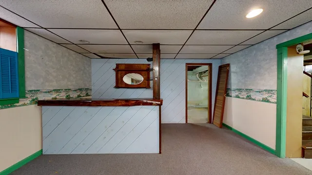 a view of hallway with refrigerator and cabinet