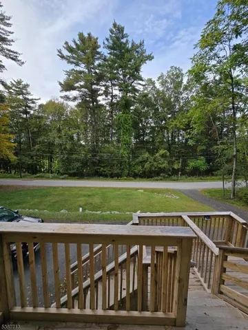 a view of a wooden deck and a yard with swimming pool