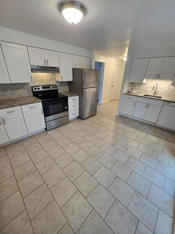 a kitchen with stainless steel appliances a refrigerator sink and cabinets