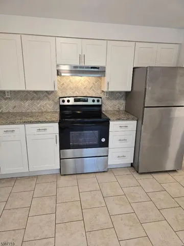 a kitchen with cabinets and a stove top oven