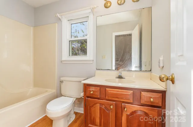 a bathroom with a sink toilet vanity and tub