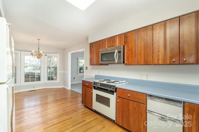 a kitchen with stainless steel appliances granite countertop a stove a sink and a microwave