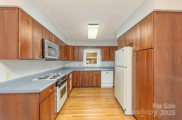 a kitchen with stainless steel appliances granite countertop a refrigerator and a stove