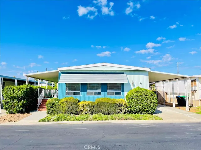 a front view of a house with a yard and potted plants