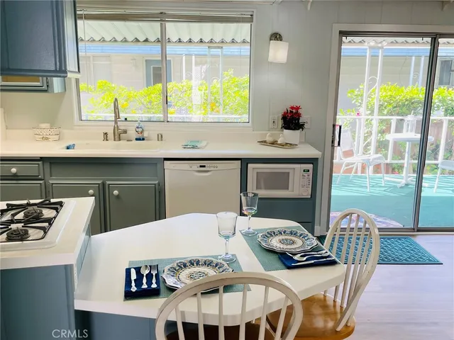 a kitchen with a table chairs a stove and a window