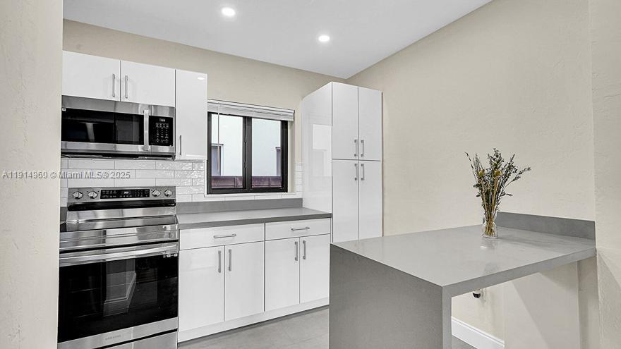 3764 Southwest 27th Lane, Unit 3762 Miami, FL 33134 - Photo 12 of 31 a kitchen with cabinets stainless steel appliances and wooden floor