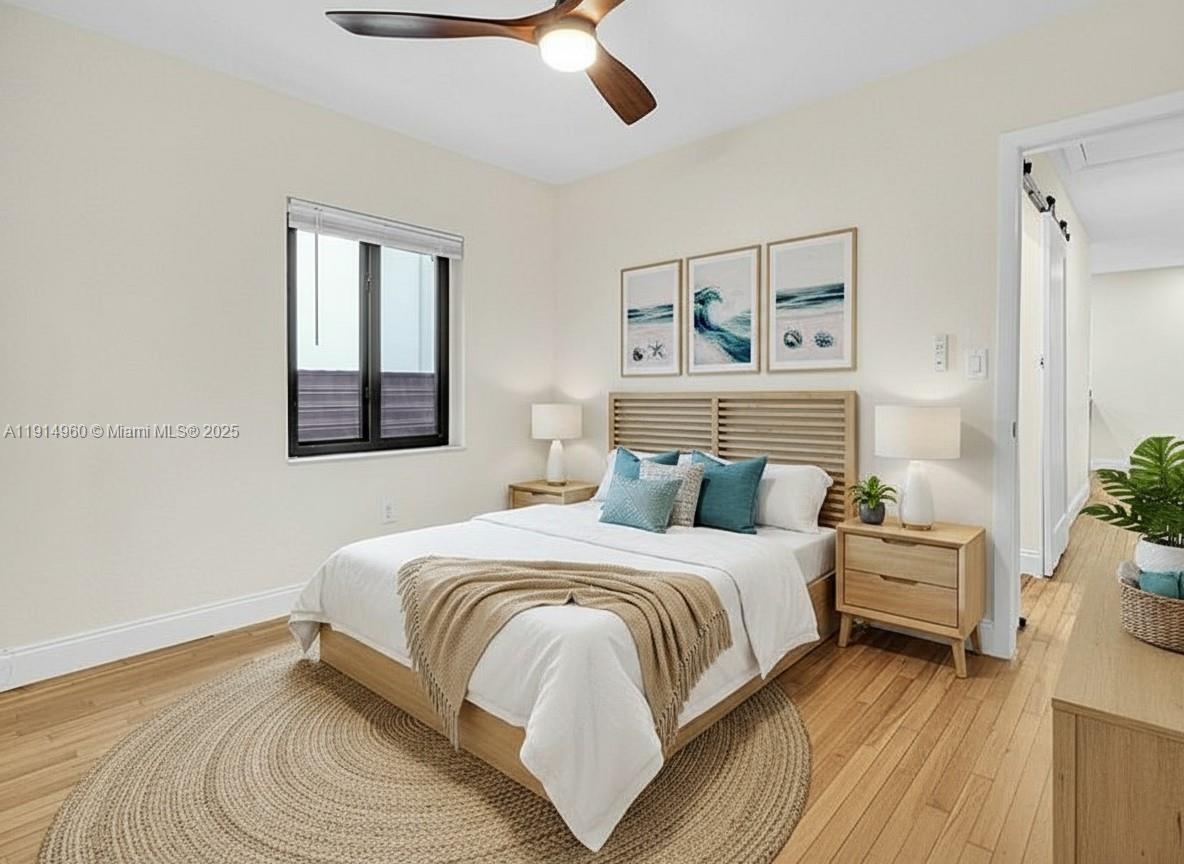 3764 Southwest 27th Lane, Unit 3762 Miami, FL 33134 - Photo 16 of 31 a bedroom with a bed wooden floor and window