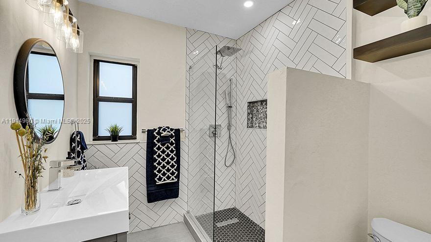 3764 Southwest 27th Lane, Unit 3762 Miami, FL 33134 - Photo 20 of 31 a bathroom with a tub sink and mirror