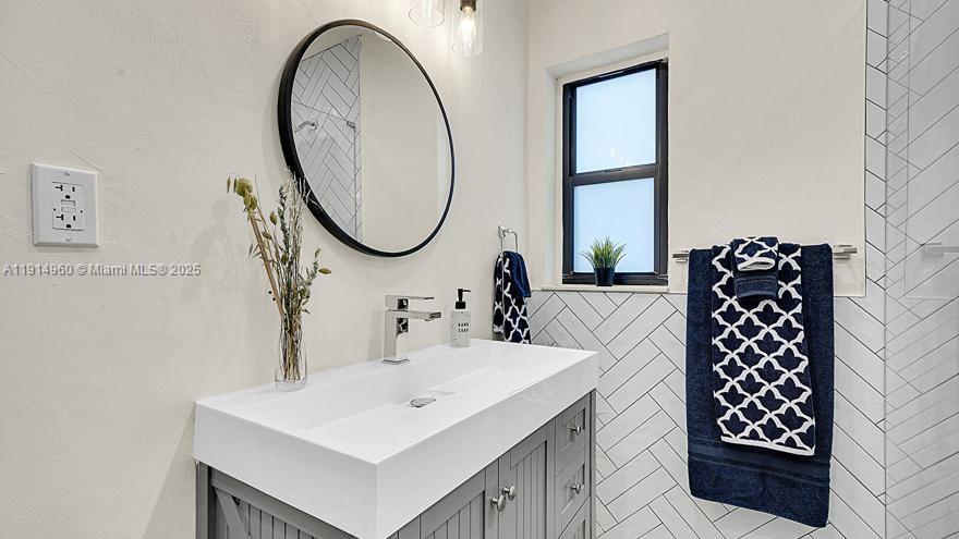 3764 Southwest 27th Lane, Unit 3762 Miami, FL 33134 - Photo 22 of 31 a bathroom with a sink a mirror and a window