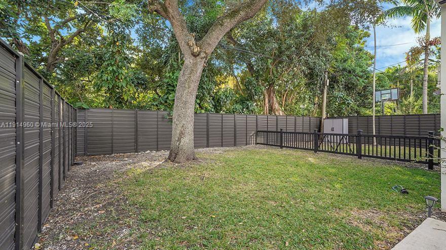 3764 Southwest 27th Lane, Unit 3762 Miami, FL 33134 - Photo 30 of 31 a view of a backyard with a trees and wooden fence