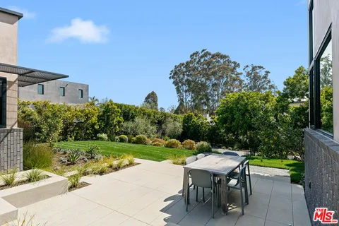 a view of a table and chairs in backyard of the house