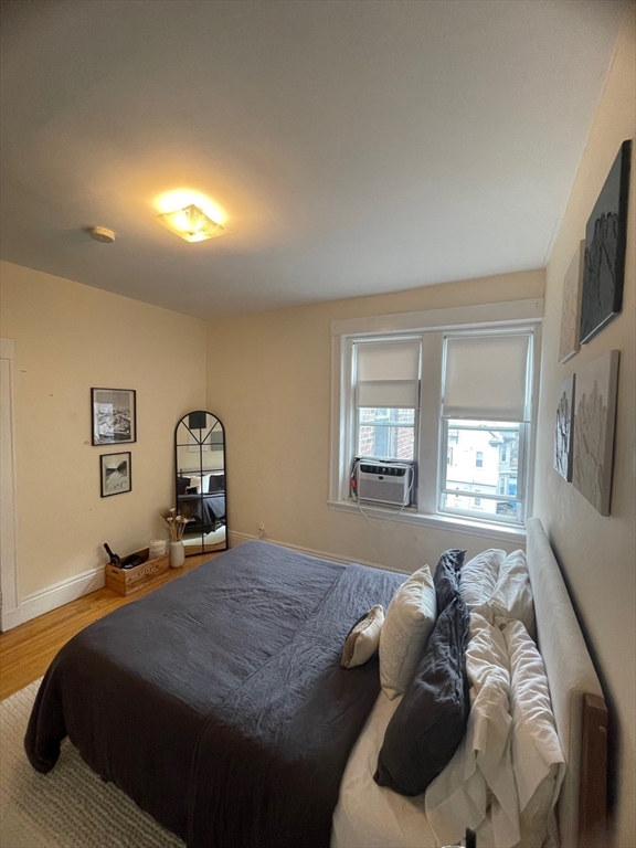 30 Reedsdale Street, Unit 6 Boston, MA 02134 - Photo 3 of 11 a bed sitting in a bedroom next to a window and a flat screen tv
