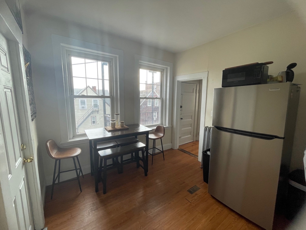 30 Reedsdale Street, Unit 6 Boston, MA 02134 - Photo 6 of 11 a kitchen with refrigerator a table and chairs