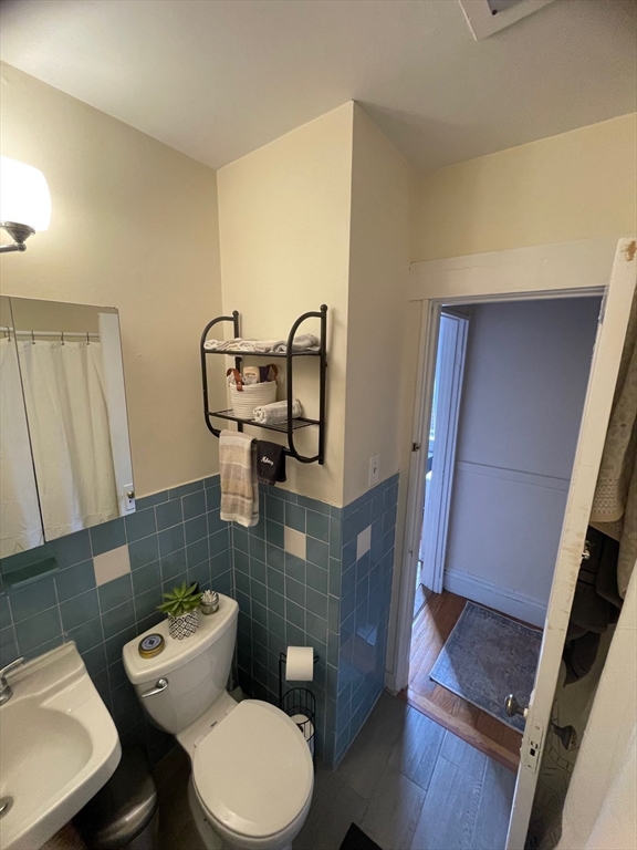 30 Reedsdale Street, Unit 6 Boston, MA 02134 - Photo 9 of 11 a bathroom with a toilet a sink and mirror