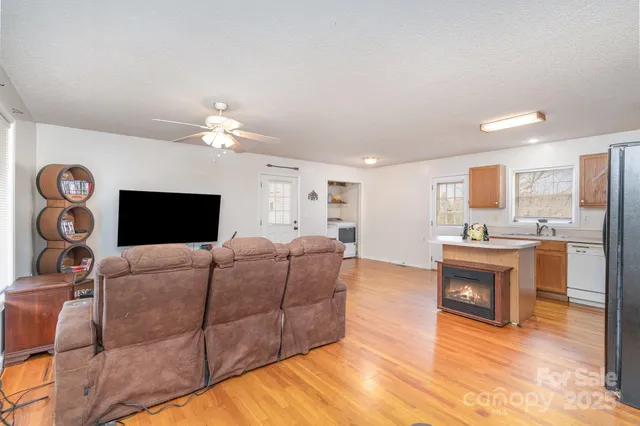 a living room with furniture a fireplace and kitchen view