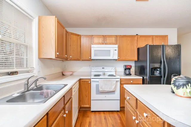 a kitchen with a sink a stove a refrigerator and cabinets