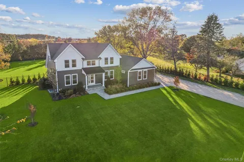 a front view of a house with a yard and trees