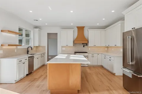 a spacious bathroom with a double vanity sink toilet mirror and shower