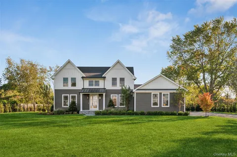 a view of a house with a big yard and large trees
