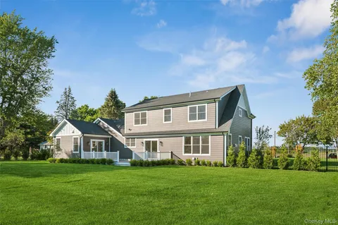 an empty room with wooden floor fireplace windows and cabinet
