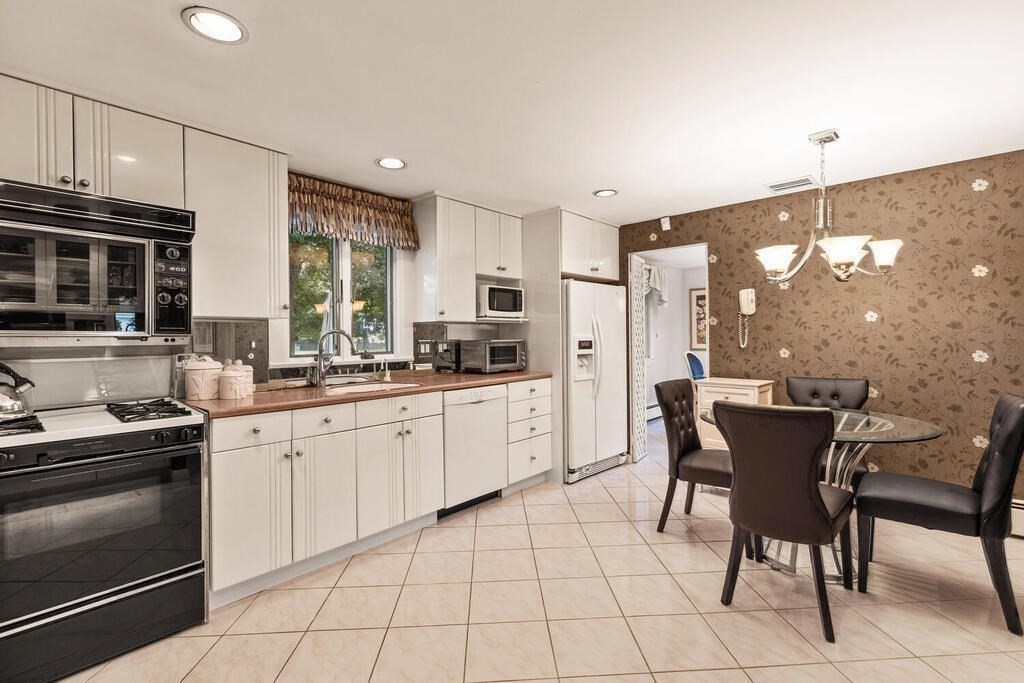 124 Damon Road Needham, MA 02494 - Photo 13 of 42 a kitchen with a dining table chairs stainless steel appliances and cabinets